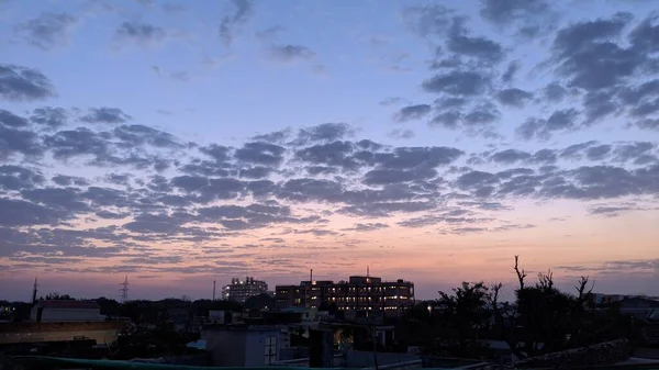 曇り空の都市の建物の暗いシルエットの上に青の夕日 トップビュー上昇した 高品質の写真 — ストック写真