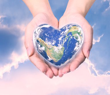World in heart shape with over women human hands