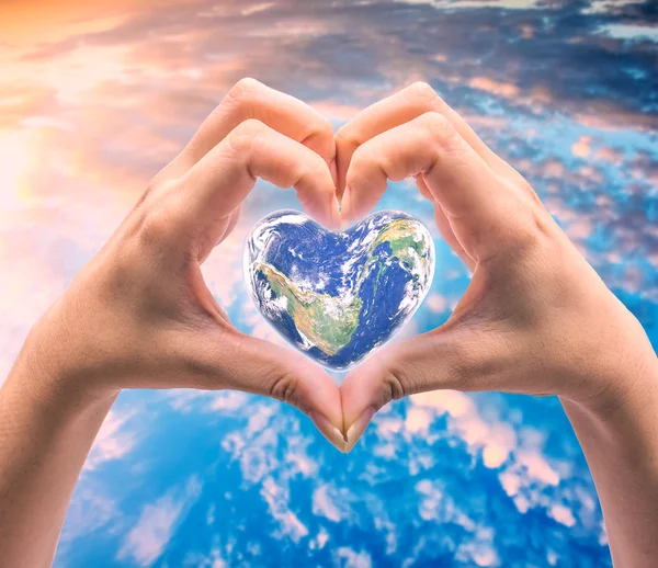 World in heart shape with over women human hands — Stock Photo, Image