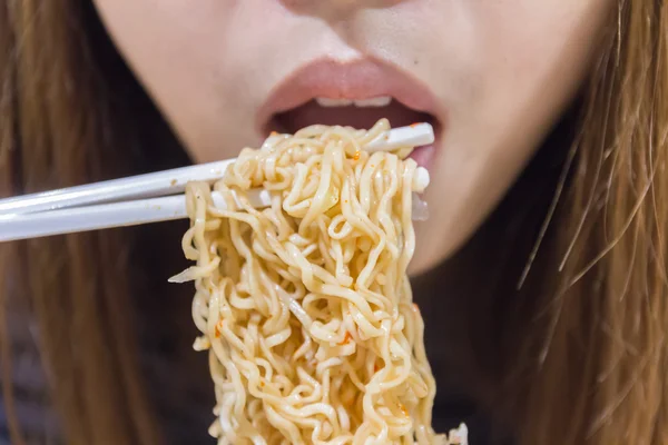 Noodle op stokjes met mensen in achtergrond, ondiepe scherptediepte — Stockfoto