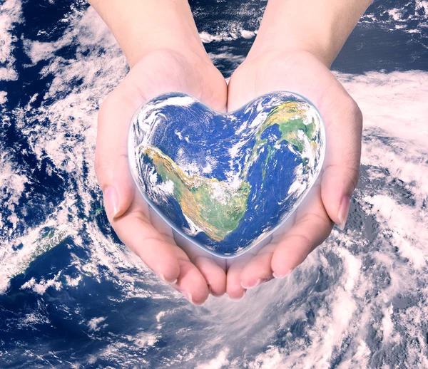 World in heart shape with over women human hands on blurred natu — Stock Photo, Image