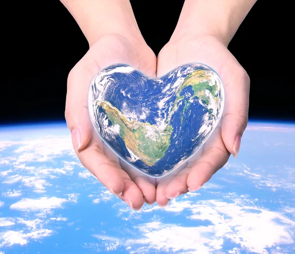 World in heart shape with over women human hands on blurred natu — Stock Photo, Image