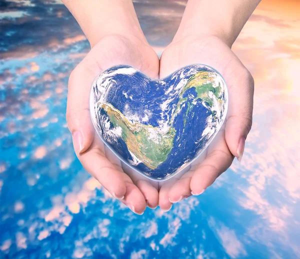 World in heart shape with over women human hands on blurred natu — Stock Photo, Image