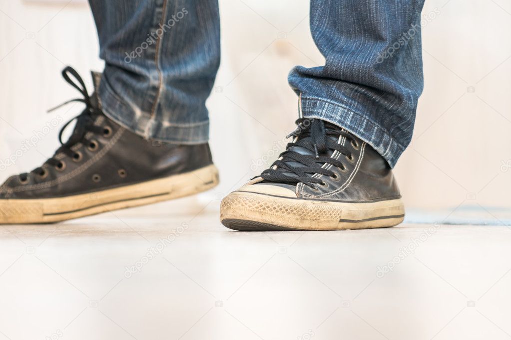 A pair of vintage looking, athletic shoes and skinny jeans