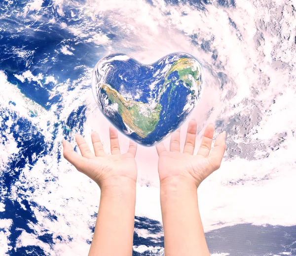 World in heart shape with over women human hands on blurred natu — Stock Photo, Image