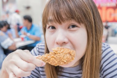 Holding ve yeme genç mutlu kadın tavuk kızartması