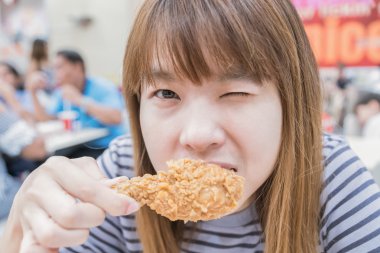 Holding ve yeme genç mutlu kadın tavuk kızartması