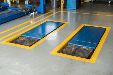 Jacks, makas vinçleri garajdaki arabayı kaldırır.