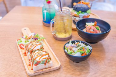 Kafede akşam yemeği, yumurtalı Benedict, avokadolu tost, karidesli makarna ve içecek.