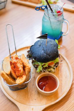 Köfteli, peynirli, domatesli, mayonezli, kağıt bardakta patates kızartması ve buzlu bir bardak soğuk kola soda. Koyu ahşap kırsal masa. Modern fast food öğle yemeği