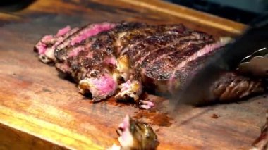 Ahşap tahtada et kesen şef.