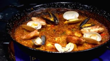 Deniz ürünleri, midye, kalamar ve maydanozlu paella pişiriyorum. tabak gurultuları