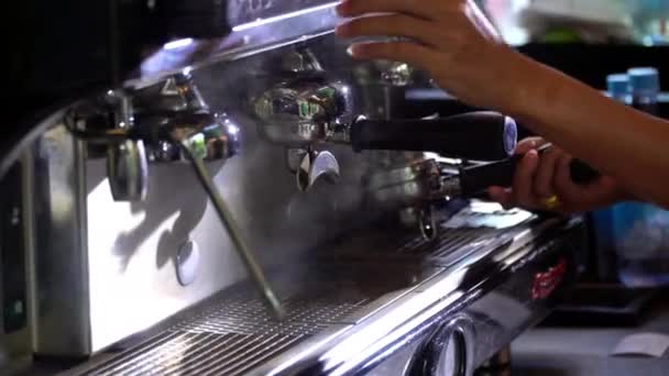 Kávéfőző gép által főzött eszpresszó, amely portafilteren keresztül áramlik a pohárba. — Stock videók