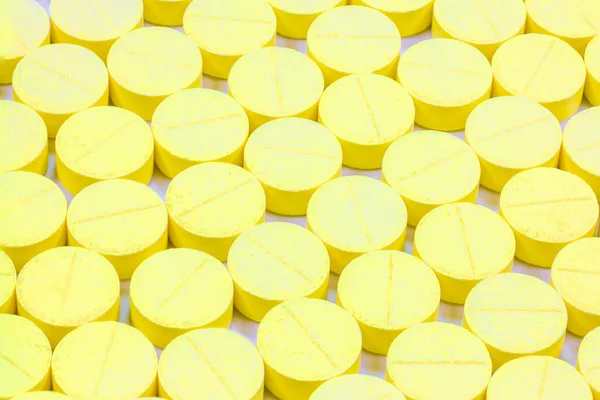 Muitos medicamentos amarelos no fundo branco — Fotografia de Stock