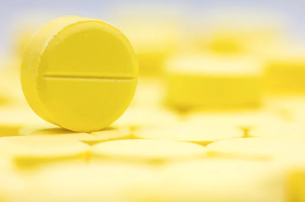 Tema da farmácia, Heap de pílulas de antibiótico comprimido redondo amarelo medicina. DOF superficial — Fotografia de Stock