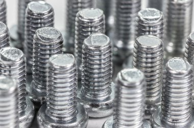 Closeup metal vida (cıvata) ve beyaz zemin üzerine fındık.