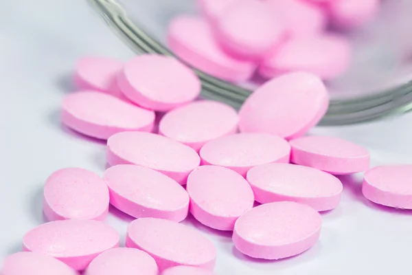 Os comprimidos cor de rosa isolados sobre fundo branco — Fotografia de Stock