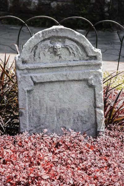 Tombstone and graves in an ancient church graveyard — Stock Photo, Image