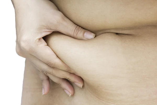 Избыточный вес женщины рука держит или щипать жир живота пинок — стоковое фото