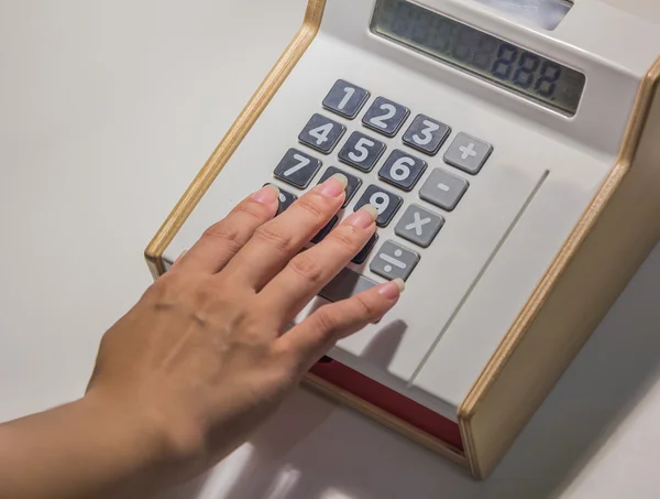 Primo piano oh mano con calcolatrice su sfondo scrivania — Foto Stock