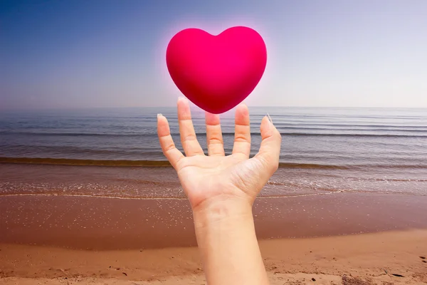 Coração rosa em mãos no fundo da natureza — Fotografia de Stock