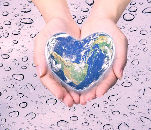 World in heart shape with over women human hands on blurred natu — Stock Photo, Image