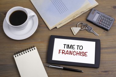 Franchise zamanı. Tahta masadaki tablet aygıtındaki metin
