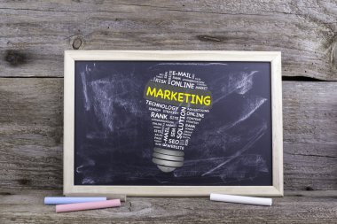 Pazarlama ampul kelime bulutu. Ahşap bir masa tahtaya tebeşir