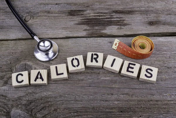 Tekst: Calorieën uit houten letters op houten achtergrond. — Stockfoto