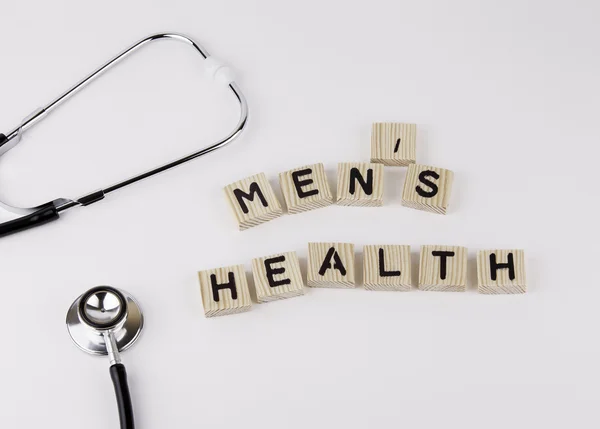 Text: MENS HEALTH from wooden letters on white office desk