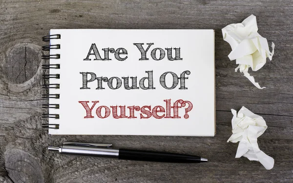 ¿Estás orgulloso de ti mismo? Texto en un bloc de notas sobre una mesa de madera . — Foto de Stock
