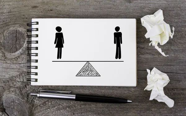 Gelijkheid van man en vrouw. Op een houten tafel notebook — Stockfoto