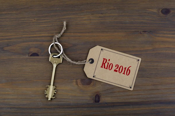 Chave e uma nota em uma mesa de madeira com texto - Rio 2016 — Fotografia de Stock