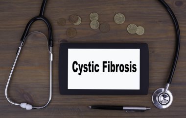 Kistik fibrozis. Tablet cihaza ahşap bir masa üzerinde metin