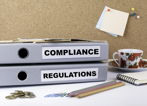 Compliance und Regulierungen - zwei Ordner über White Office des — Stockfoto