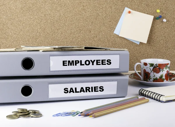 Співробітники та зарплати - дві папки на білому офісі — стокове фото