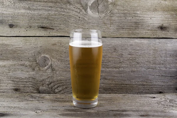 木製の背景に光のビールのグラス — ストック写真