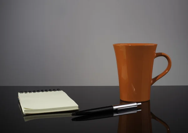 Tazza, penna e taccuino da caffè su superficie lucida — Foto Stock