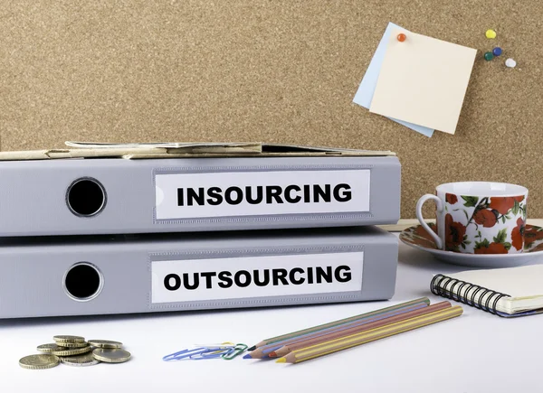 Insourcing e Outsourcing - duas pastas no escritório branco des — Fotografia de Stock