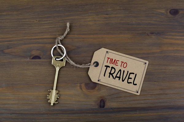 Ключ и записка на деревянном столе с текстом - Время путешествовать — стоковое фото