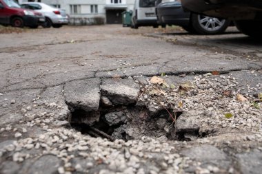 Hasarlı yol yüzeyi. Tehlike ve altyapı. Apartman binalarının avlusu