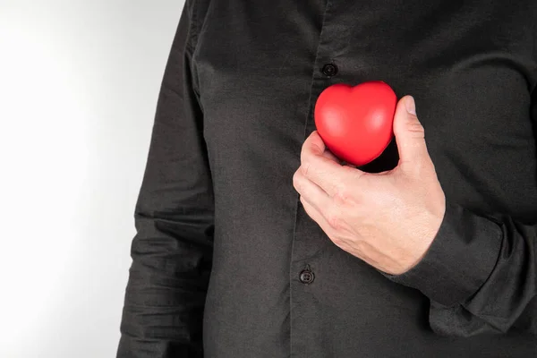 Heart diseases. Man holding red heart at chest. Health concept — Stock Photo, Image