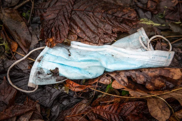 Yüzü eski yapraklarla kaplı. Covid-19 sırasındaki atıklar plastik kirliliğine yol açıyor — Stok fotoğraf