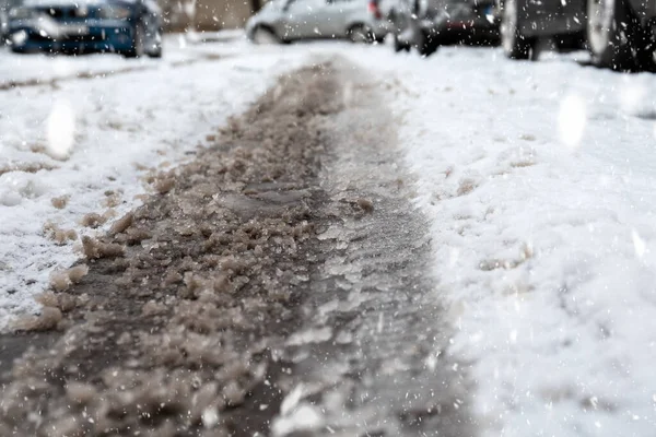 Estradas nevadas e difíceis após a queda de neve no inverno. Impressão de pneu lamacento na neve, carros embaçados no fundo — Fotografia de Stock