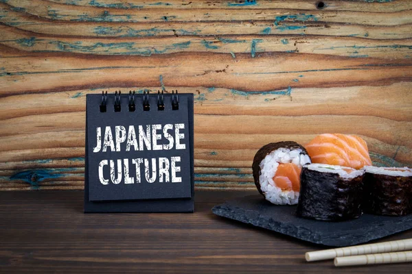 Japonská kultura. Notebook a sushi na dřevěném stole — Stock fotografie
