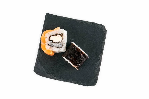 Sushi rolka s lososem a kamenným povrchem na bílém pozadí. Jídlo a japonská kultura — Stock fotografie