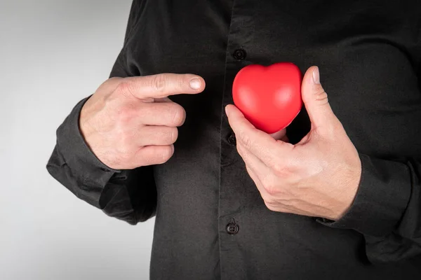 Серцевий напад, хвороба чи кохання. Людина з червоним гумовим серцем — стокове фото
