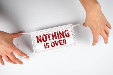 Hiçbir şey bitmedi. Covid-19, sağlık ve tıp konsepti. Yüz maskesi ellerinde