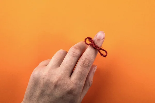 Corde rouge attachée autour d'un doigt. Mémoire et noeud de rappel — Photo