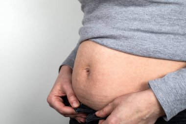 Şişman kadın düğmeleri iliklenmemiş. Sağlık, diyet ve aktif yaşam tarzı